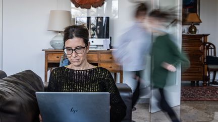 Une mère de famille télétravaille en gardant ses enfants à la maison, le 20 mars 2021. Photo d'illustration. (CRISTIANO MINICHIELLO / AVALON / MAXPPP)