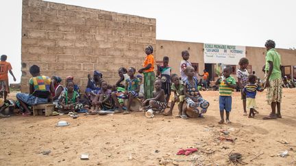 Des femmes et des enfants burkinabè devant une école à Ouagadougou, au nord du Burkina Faso, le 13 juin 2019. (OLYMPIA DE MAISMONT / AFP)