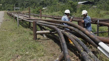 Deux hommes travaillant sur une exploitation pétrolière dans la réserve Yasuni, en Équateur, en 2018. (MAJORITY WORLD / UNIVERSAL IMAGES GROUP EDITORIAL / VIA GETTY)