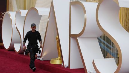 Un technicien marche sur le fameux tapis rouge durant la préparation de la 92e cérémonie des Oscars, samedi 8 février 2020 à Los Angeles. (JOHN LOCHER/AP/SIPA / SIPA)