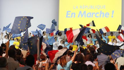 Des militants La République en Marche (LREM) agitent des drapeaux lors d'un meeting du parti, le 8 juillet 2017.&nbsp; (FRANCOIS GUILLOT / AFP)