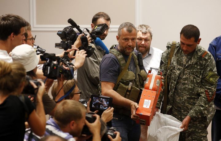 Un s&eacute;paratiste pro-russe montre les bo&icirc;tes noires de l'avion MH17 de Malaysia Airlines, le 22 juillet 2014, &agrave;&nbsp;Donetsk (Ukraine). (MAXIM ZMEYEV / REUTERS)