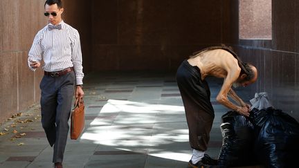 Un sans-abri (D) fouille dans ses sacs, &agrave; c&ocirc;t&eacute; d'un tribunal &agrave; Los Angeles (Californie, Etats-Unis), le 8 juillet 2014. ( LUCY NICHOLSON / REUTERS)