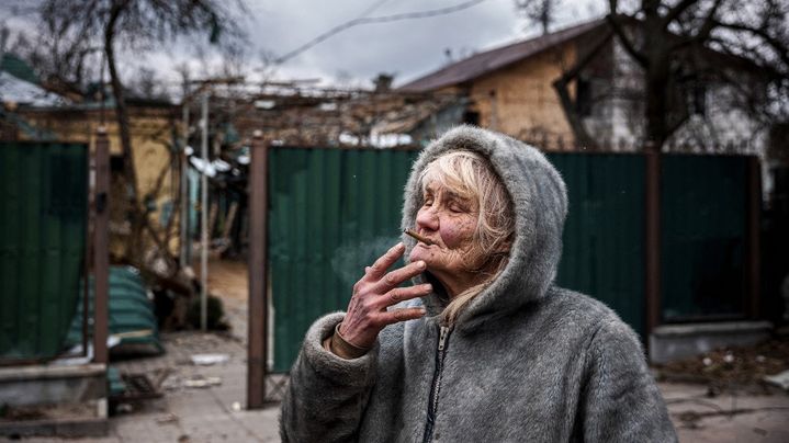 13 mars 2022. Vera Tsyghanova, 76 ans, fume une cigarette devant sa maison qui a été touchée par un bombardement à Irpin au nord ouest de Kiev.&nbsp; (DIMITAR DILKOFF / AFP)