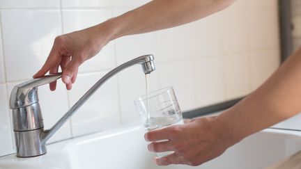 Une femme se sert un verre d'eau à Paris, le 11 mars 2014. (GARO / PHANIE)