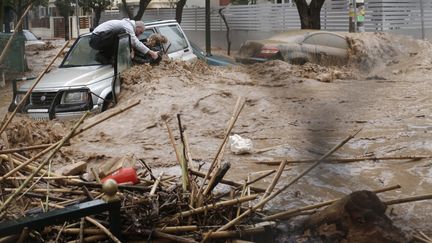 Le 22 f&eacute;vrier 2013, des pluies diluviennes s&rsquo;abattent sur Ath&egrave;nes (Gr&egrave;ce). En quelques minutes, les axes routiers se transforment en torrents de boue. Prise au pi&egrave;ge dans son v&eacute;hicule, cette femme ne doit la vie qu&rsquo;&agrave; son miraculeux sauveteur. Une autre aura moins de chance. La violence de ces inondations, in&eacute;dite depuis plus d&rsquo;un demi-si&egrave;cle fera une victime. (JOHN KOLESIDIS / REUTERS)