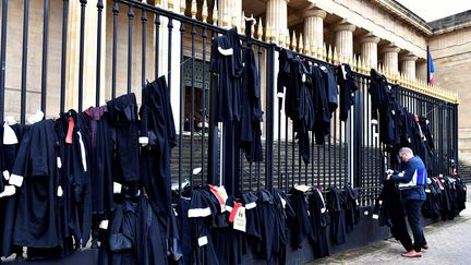 Des robes d'avocats suspendues à la grille du tribunal de Bordeaux (Gironde) pour protester contre la réforme des retraites et la fin de leur régime autonome, le 17 janvier 2020. (GEORGES GOBET / AFP)