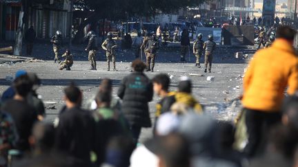 Des manifestants face aux forces de l'ordre sur une place de Bagdad, en Irak, le 27 janvier 2020 (AHMAD AL-RUBAYE / AFP)