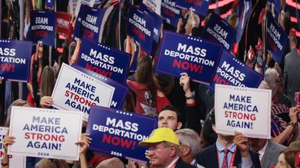 Des militants trumpistes brandissent des pancartes "déportation massive maintenant" lors de la convention nationale du Parti républicain, à Milwaukee (Wisconsin, Etats-Unis), le 17 juillet 2024. (SCOTT OLSON / GETTY IMAGES NORTH AMERICA / AFP)