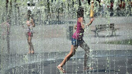 Des enfants se rafraîchissent dans une fontaine d'Albi (Tarn), le 5 août 2018.&nbsp; (REMY GABALDA / AFP)