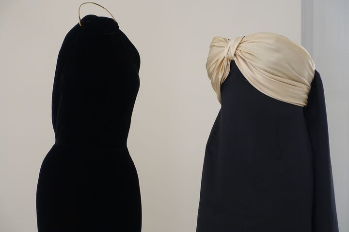 Exposition "Alaïa et Balenciaga. Sculpteurs de la forme" : à gauche, robe longue dos nu en velours noir avec une bride en cuir or Alaia couture hiver 2008. A droite, robe bustier longue, en satin de soie noir, avec noeud champagne à la poitrine Balenciaga haute couture hiver 1959.&nbsp; (CORINNE JEAMMET)