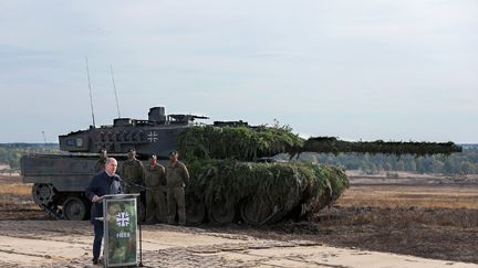 Le chancelier allemand Olaf Scholz s'exprime près d'un char Leopard 2, à Ostenholz (Allemagne), le 17 octobre 2022, à l'occasion de sa visite sur un terrain de l'armée allemande, la Bundeswehr. (RONNY HARTMANN / AFP)