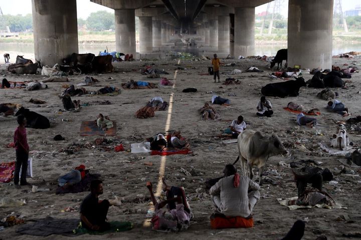 La population cherche vainement des zones d'ombre, en se reposant notamment&nbsp;sous un pont enjambant le lit de la rivière Yamuna à New Delhi, en Inde, le 10 mai 2022. (AMARJEET KUMAR SINGH / ANADOLU AGENCY / AFP)