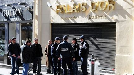 Des policiers discutent devant la bijouterie qui a &eacute;t&eacute; la cible d'un braquage avort&eacute; et o&ugrave; un passant a &eacute;t&eacute; bless&eacute; par balle, le 26 f&eacute;vrier 2012 dans le centre-ville de Marseille. (GERARD JULIEN / AFP)