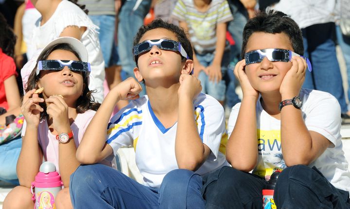 Des enfants regardent une &eacute;clipse solaire depuis Tunis au moyen de lunettes sp&eacute;ciales, le 3 novembre 2013. (FETHI BELAID / AFP)