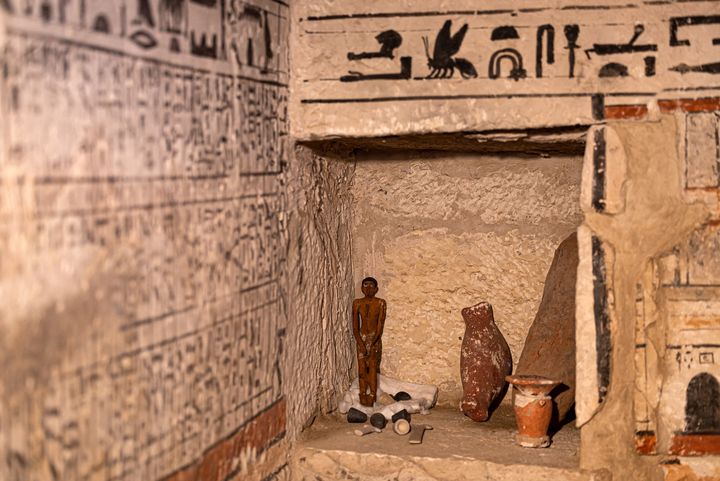 Une statuette et d'autres objets dans la tombe de Henu, l'une des cinq découvertes à Saqqara. 
 (KHALED DESOUKI / AFP)