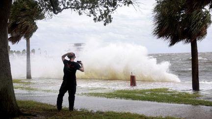 Une personne filme l'océan alors que l'ouragan Hélène s'approche des côtes de Floride (Etats-Unis), dans la ville de St. Petersburg, le 26 septembre 2024. (JOE RAEDLE / AFP)