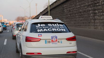 Un voiture d'auto-&eacute;cole protestant contre la loi Macron, sur le p&eacute;riph&eacute;rique parisien, le 6 f&eacute;vrier 2015. (JEAN PIERRE NGUYEN VAN HAI-BARBIER / CITIZENSIDE / AFP)