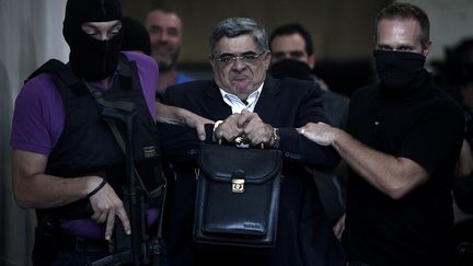 Le leader d'Aube dor&eacute;e, Nikos Michaloliakos, arr&ecirc;t&eacute; par la police le 28 septembre 2013. (ANGELOS TZORTZINIS / AFP)