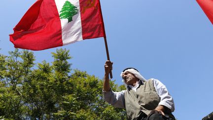 Un homme agite le drapeau du parti communiste libanais, &agrave; Beyrouth. (JAMAL SAIDI / REUTERS)