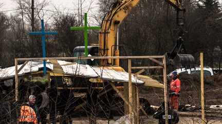 Des policiers français protégeant un bulldozer qui a détruit une église et une mosquée dans la jungle de Calais (Pas-de-Calais), lundi 1er février. (PHILIPPE HUGUEN / AFP)