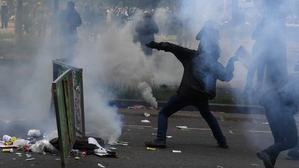 Un homme lance un projectile en direction de policiers en marge du défilé du 1er-Mai à Paris, le 1er mai 2018. (ALAIN JOCARD / AFP)