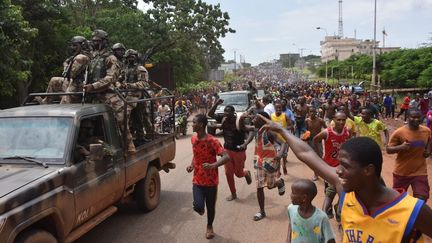 La foule en liesse accompagne des soldats qui viennent de prendre le pouvoir le 5 septembre 2021 à Conakry, capitale de la Guinée. (CELLOU BINANI / AFP)