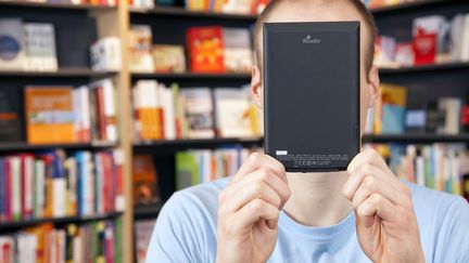 Un homme lisant un e-book dans une librairie en Allemagne, en janvier 2012. (KIEFER / VARIO IMAGES / SIPA)