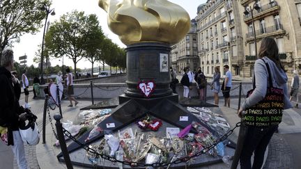 Le 31 ao&ucirc;t 2012, des gens rendent hommage &agrave; Lady Diana &agrave; c&ocirc;t&eacute; du tunnel du pont de l'Alma, &agrave; Paris, o&ugrave; la princesse a trouv&eacute; la mort, le 31 ao&ucirc;t 1997. (BERTRAND GUAY / AFP)