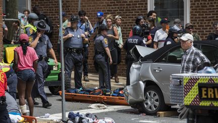 La police et le personnel médical entourent la voiture qui a foncé sur des manifestants antiracistes à Charlottesville (Virginie, Etats-Unis), le 12 août 2017. (SAMUEL CORUM / ANADOLU AGENCY)