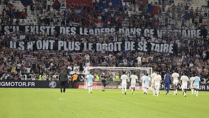 Les joueurs lyonnais se dirigent vers leurs supporters après la défaite contre le PSG, le 3 septembre 2023. (JEAN CATUFFE / AFP)