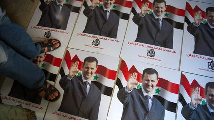 Un homme marche sur des affiches du pr&eacute;sident syrien Bachar Al-Assad, dans les locaux de l'Arm&eacute;e syrienne libre, &agrave; Tal Rifaat, le 22 ao&ucirc;t 2012. (PHIL MOORE / AFP)