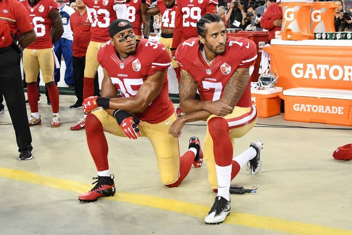 Les joueurs&nbsp;de football américain Eric Reid et Colin Kaepernick s'agenouillent durant l'hymne national, le 12 septembre 2016, avant un match entre San Francisco et Los Angeles à Santa Clara (Californie). (THEARON W. HENDERSON / GETTY IMAGES NORTH AMERICA / AFP)