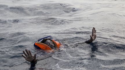 NOVEMBRE. Un migrant sur le point d'être secouru par l'ONG allemande Sea-Watch, le 6 novembre 2017 au large de la Libye. (ALESSIO PADUANO / AFP)