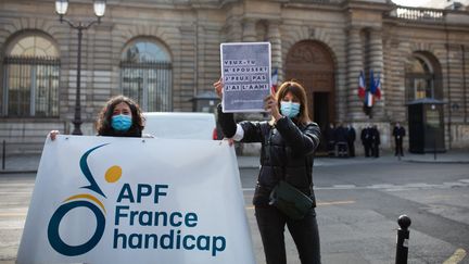 Une manifestante avec une&nbsp;pancarte : "Veux tu m'epouser ? Je peux pas, j'ai l'AAH", le 9 mars 2021, à Paris. (RAPHAEL KESSLER / HANS LUCAS / AFP)