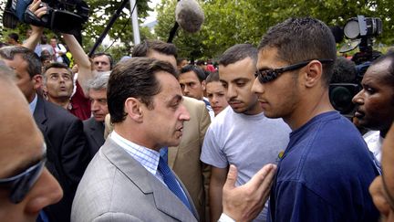 K&Auml;RCHER / RACAILLES (2005) Apr&egrave;s une visite &agrave; La Courneuve, Nicolas Sarkozy d&eacute;clare qu'il faut nettoyer la Cit&eacute; des 4 000 au K&auml;rcher. Quelques mois plus tard, il emploie le terme "racailles" en visite &agrave; Argenteuil et d&eacute;cha&icirc;ne la col&egrave;re dans les banlieues. (STEPHANE DE SAKUTIN / AFP)