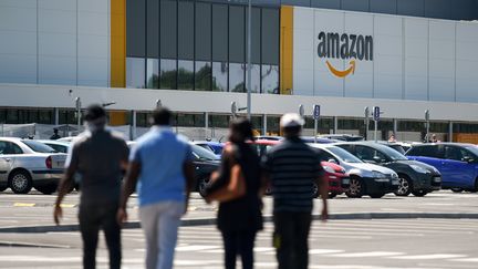 Des employés d'Amazon arrivent à l'entrepôt de Bretigny-sur-Orge (Essonne), le 19 mai 2020. (ERIC PIERMONT / AFP)