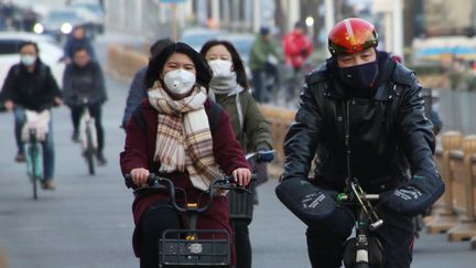 Des passants portent des masques de protection à Pékin (Chine), le 21 janvier 2020. (KOKI KATAOKA / YOMIURI)