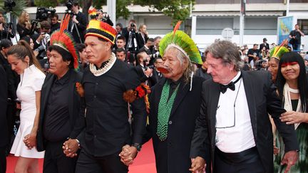 Le chef Raoni (au centre avec une couronne verte) de la tribu du peuple indigène Kayapo au Brésil, a monté les marches jeudi soir avec sa fille (à droite) dans le cadre de la campagne internationale pour la protection de la forêt amazonienne. (DANIELE VENTURELLI / WIREIMAGE)