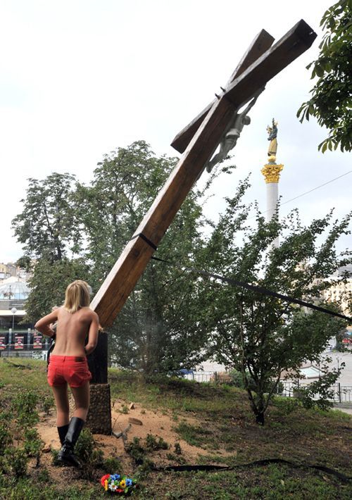 Une militante du mouvement ukrainien Femen, scie à la tronçonneuse une croix en soutien aux Pussy Riot.
 (Genya Savilov / AFP)