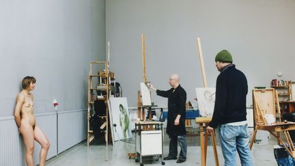 Elina Brotherus interroge les rapport entre photograophie et peinture mais également la représentation de l'artiste au modèle. L’artiste pose nue, dans un atelier vide, devant deux peintres formés à la tradition classique du
	portrait à l’académie russe de Saint-Pétersbourg. L’artiste devient ainsi à la fois un modèle pour les deux peintres mais aussi le modèle de sa propre photographie.
 (Elina Brotherus)