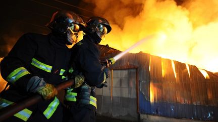 Photo transmise par les Sapeurs-Pompiers de Paris, le 11 mars 2012. Des pompiers luttant contre un incendie qui s'est d&eacute;clar&eacute; dans la nuit dans une zone de 10.000 m2 d'entrep&ocirc;ts &agrave; Gagny. (JULIEN PICHOT / SAPEURS-POMPIERS DE PARIS)