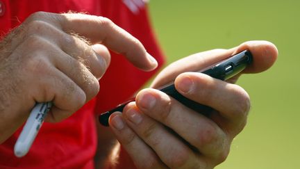 Le golfeur Ian Poulter utilise son téléphone pendant le championnat PGA sur le parcours du&nbsp;Hazeltine National Golf Club, dans le Minnesota (Etats-Unis), le 11 août 2009. (SCOTT HALLERAN / GETTY IMAGES NORTH AMERICA / AFP)