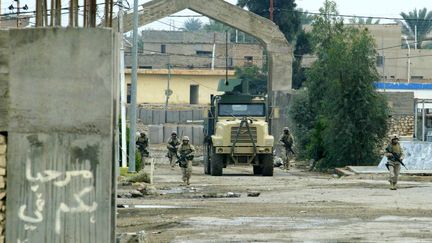 Des soldats am&eacute;ricaines patrouillent dans la ville d'Al-Qaim (Irak), qui se situe en face de la ville syrienne de&nbsp;Boukamal, le 6 novembre 2004. (LOUAI BESHARA / AFP)