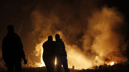 Des Palestiniens ont tent&eacute; d'&eacute;teindre le feu d&eacute;clench&eacute; apr&egrave;s un raid a&eacute;rien dans la ville de Gaza, dans la nuit du mercredi 14 novembre 2012. (MOHAMMED ABED / AFP)