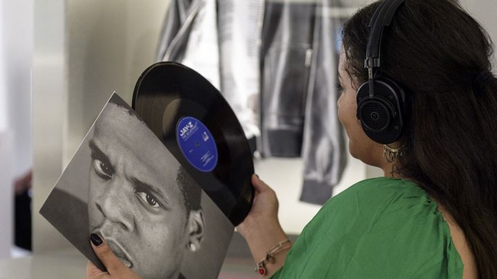 Une femme écoute une musique de Jay-Z à l'exposition "The Book of HOV" à la grande bibliothèque de Brooklyn, le 17 juillet 2023. (ANGELA WEISS / AFP)