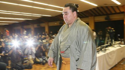 Le "grand champion" Harumafuji quitte la salle de presse après avoir annoncé sa retraite Dazaifu, au Japon, le 29 novembre 2017, pour expier son comportement brutal envers un autre sumo mongol. (AFP / JIJI PRESS)