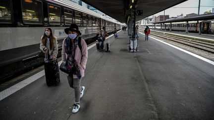 Des voyageurs marchent sur un quai après être descendus d'un train arrivant à Paris, le 17 mars 2020. (CHRISTOPHE ARCHAMBAULT / AFP)