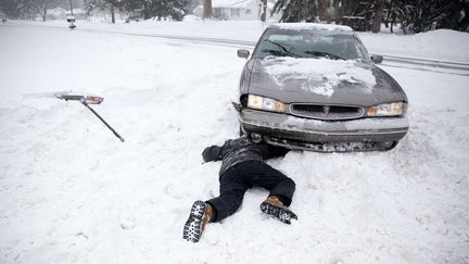 Burton, le 6 janvier 2014. 33 cm de neige. Record. Joseph Mosciski, 22 ans, tente d'enlever la neige coin&ccedil;ant une voiture.&nbsp; (MICHELLE TESSIER / AP / SIPA)