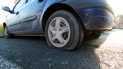 Une voiture aux pneux crevés, à Douai. (Photo d'illustration) (JOHAN BEN AZZOUZ / MAXPPP)